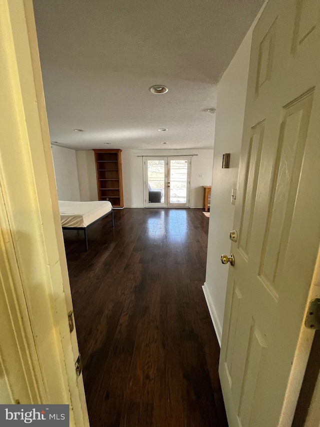 hallway featuring baseboards, dark wood-type flooring, and french doors