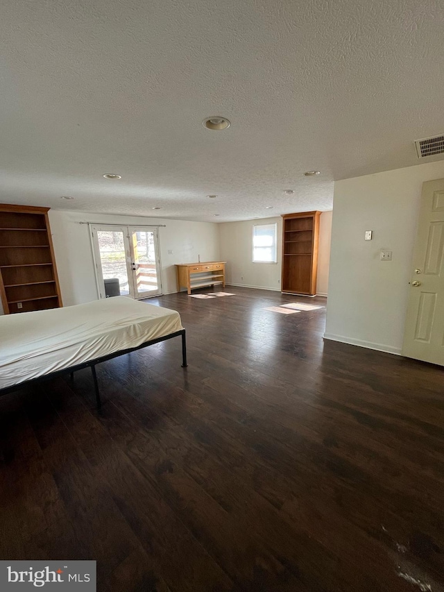 playroom featuring dark wood-style floors, baseboards, visible vents, and a textured ceiling