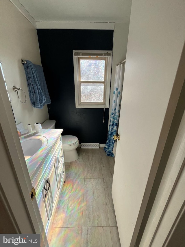 bathroom featuring visible vents, a shower with shower curtain, toilet, vanity, and baseboards