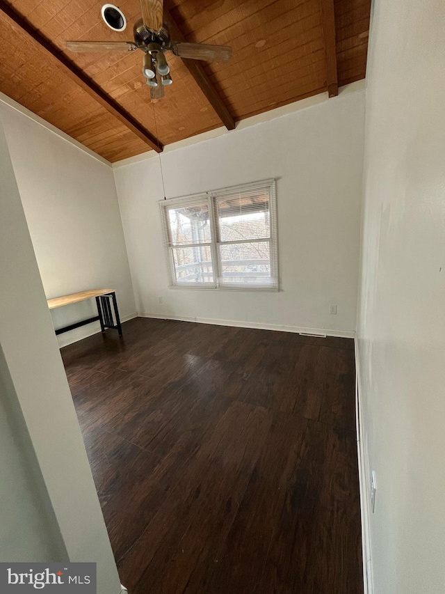 spare room with ceiling fan, vaulted ceiling with beams, dark wood-type flooring, wood ceiling, and baseboards