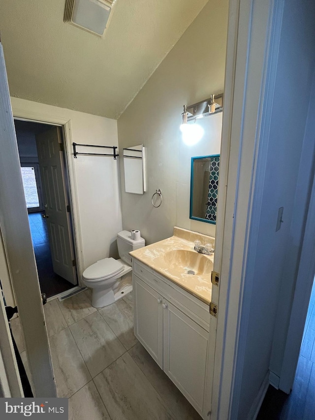 bathroom with toilet, a shower with curtain, visible vents, and vanity