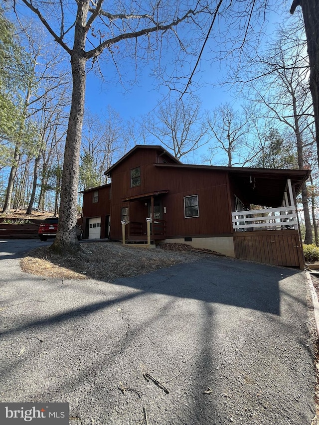 view of front of house with aphalt driveway, crawl space, and a porch