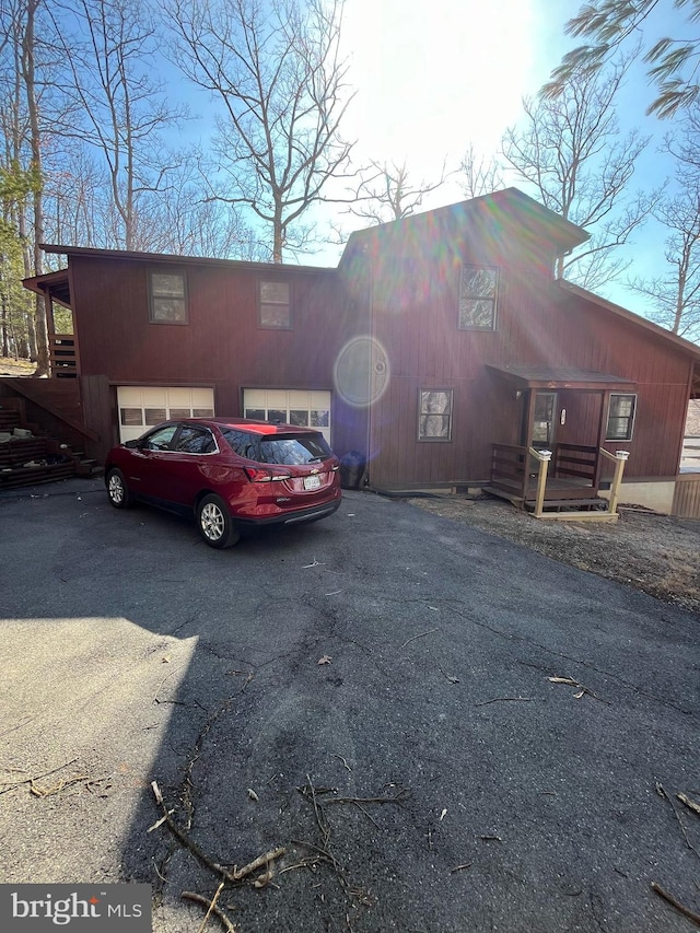 exterior space featuring aphalt driveway and an attached garage