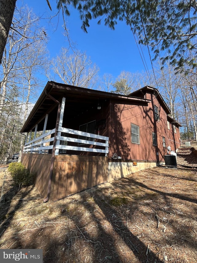 view of side of property with crawl space and cooling unit