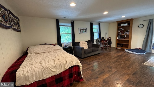 bedroom with a textured ceiling, visible vents, wood finished floors, and recessed lighting