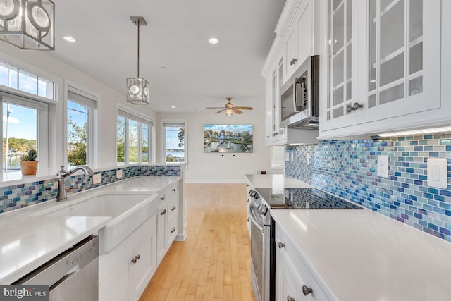 kitchen featuring white cabinetry, appliances with stainless steel finishes, light countertops, and a sink