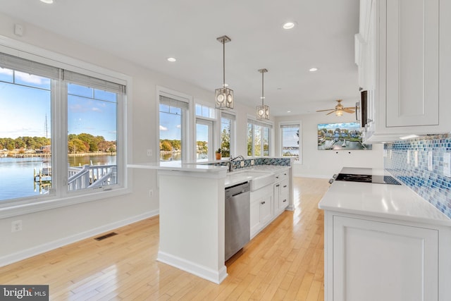 kitchen with tasteful backsplash, white cabinets, a sink, light wood-type flooring, and dishwasher