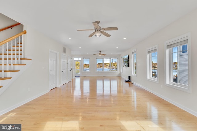 unfurnished living room featuring light wood finished floors, stairway, visible vents, and recessed lighting