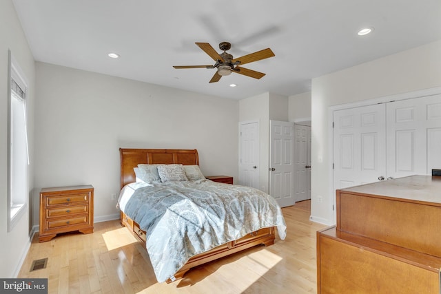 bedroom with recessed lighting, visible vents, baseboards, multiple closets, and light wood finished floors