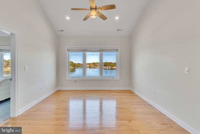 empty room featuring light wood-type flooring, visible vents, and baseboards