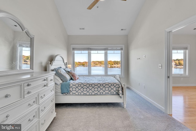 bedroom with vaulted ceiling, visible vents, and baseboards