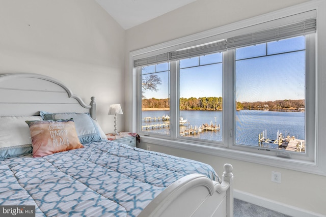 bedroom featuring carpet, a water view, vaulted ceiling, and baseboards