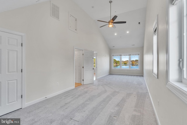 unfurnished living room with carpet floors, high vaulted ceiling, visible vents, and baseboards