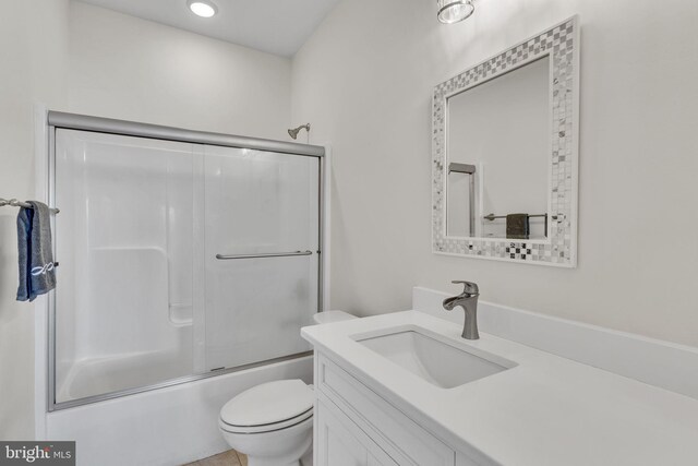 full bathroom featuring toilet, shower / bath combination with glass door, and vanity