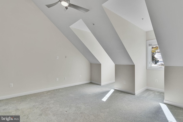 bonus room with light carpet, baseboards, vaulted ceiling, and a ceiling fan