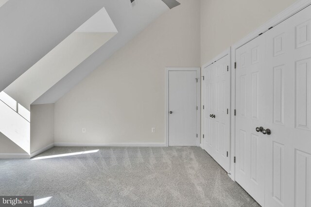 bonus room with lofted ceiling and carpet flooring