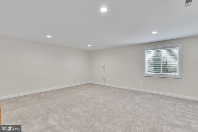 carpeted empty room featuring baseboards, visible vents, and recessed lighting