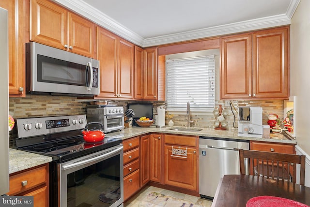 kitchen featuring stainless steel appliances, light stone counters, a sink, and brown cabinets