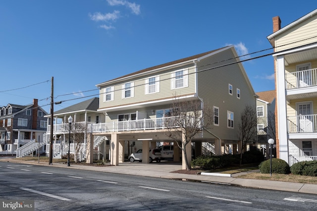 view of front of home with stairs, a residential view, and a carport