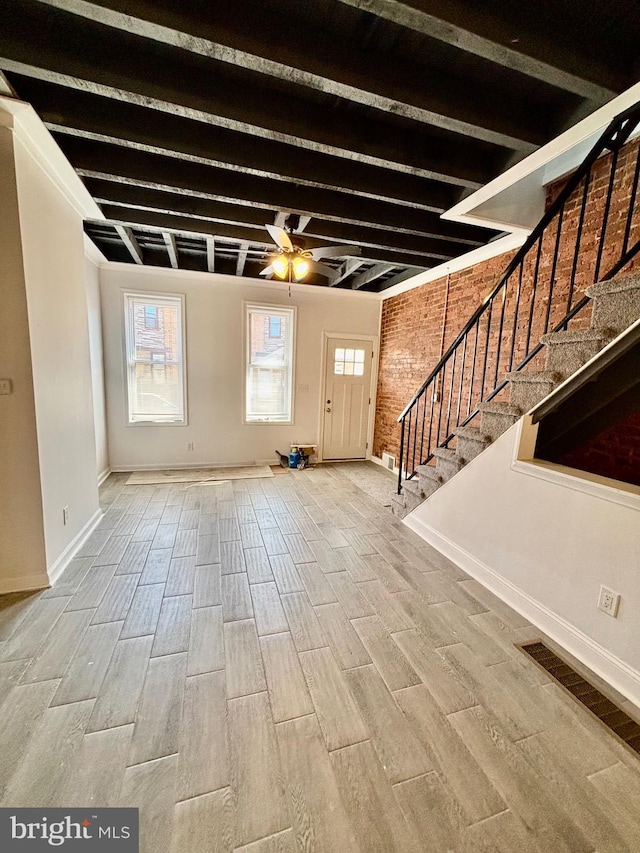 entryway featuring stairway, wood tiled floor, ceiling fan, brick wall, and beamed ceiling