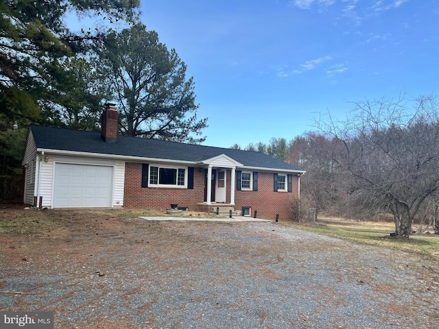 single story home featuring brick siding, a garage, dirt driveway, and a chimney