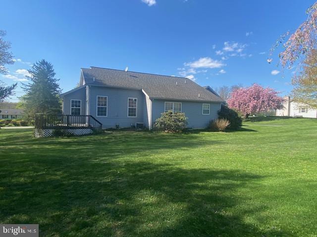 back of property featuring a deck and a yard