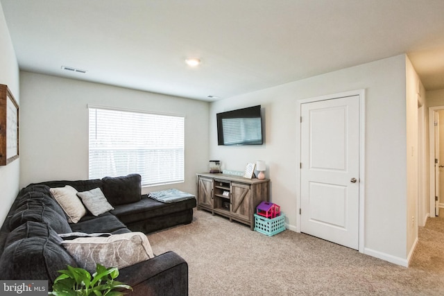 living room with baseboards, visible vents, and light colored carpet