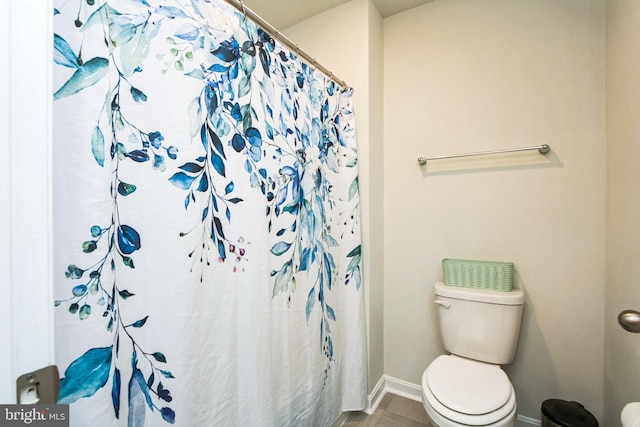 full bathroom with toilet, curtained shower, and baseboards