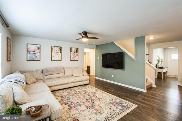 living room with ceiling fan, stairs, baseboards, and dark wood finished floors