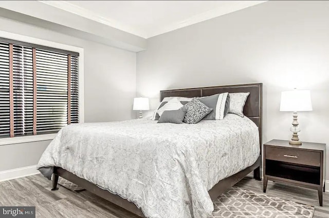 bedroom with baseboards and wood finished floors