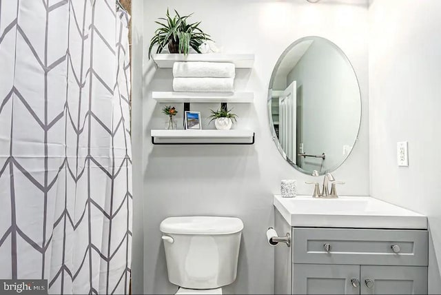 full bathroom with curtained shower, vanity, and toilet