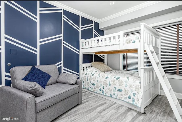 bedroom with ornamental molding and wood finished floors