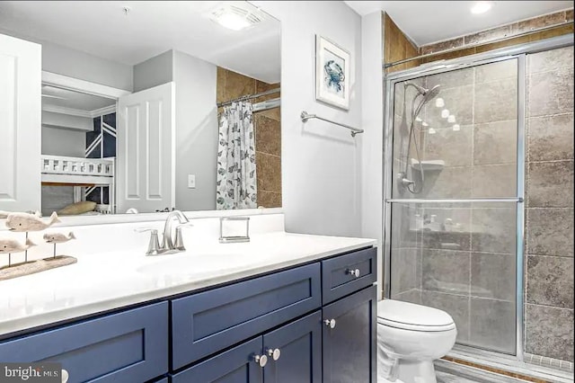 full bathroom with toilet, a shower stall, and vanity