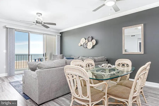 dining space featuring baseboards, a ceiling fan, and crown molding