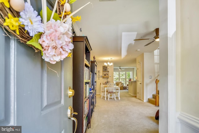 carpeted entrance foyer with ceiling fan, stairway, and visible vents