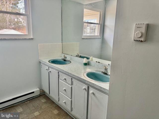 bathroom featuring double vanity, a baseboard radiator, and a sink