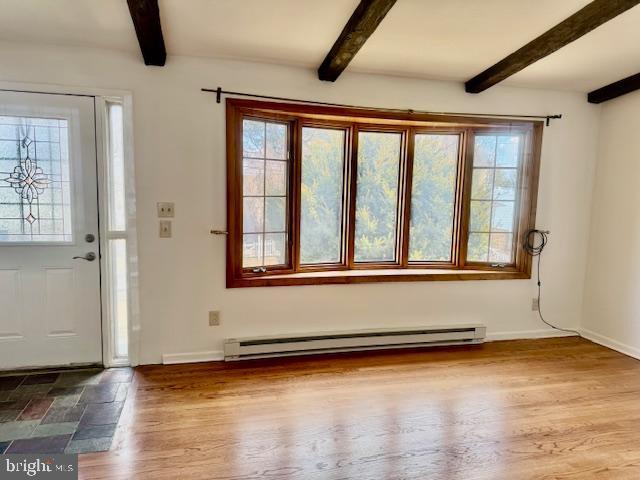 foyer featuring a baseboard heating unit, wood finished floors, and beamed ceiling