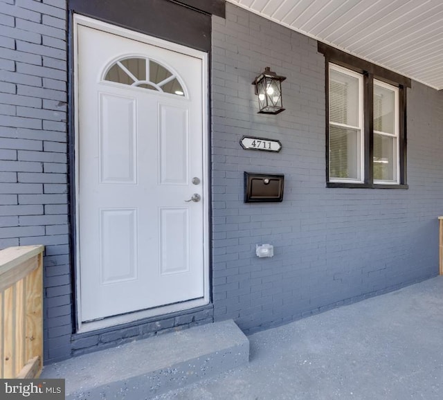 entrance to property featuring brick siding