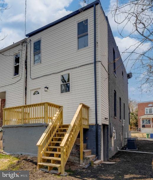 back of house with stairs and central AC unit