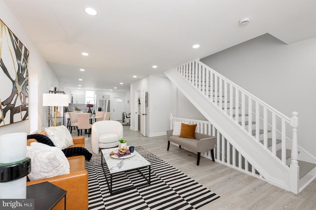 living room featuring light wood-style floors, recessed lighting, stairway, and baseboards