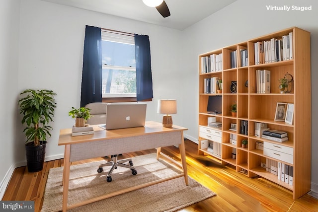 office area featuring baseboards, light wood-style flooring, and a ceiling fan