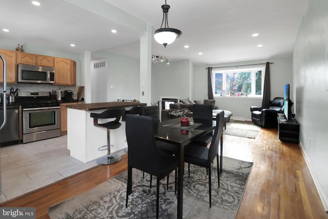 dining room featuring visible vents, recessed lighting, baseboards, and light wood-style floors