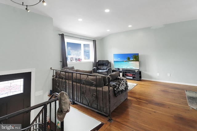 living area with recessed lighting, baseboards, wood finished floors, and vaulted ceiling