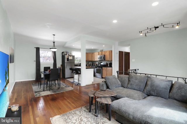 living area featuring recessed lighting, baseboards, light wood-style flooring, and track lighting