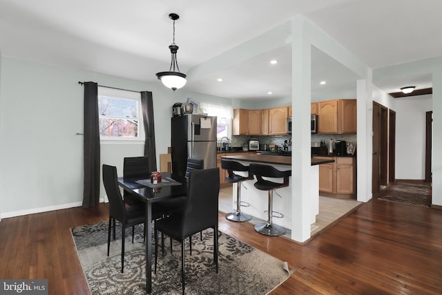 dining room with recessed lighting, baseboards, and light wood-type flooring