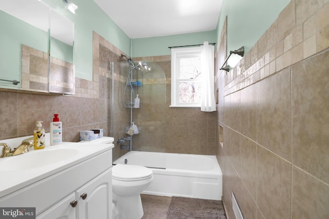 bathroom featuring tile patterned floors, toilet, tile walls, tub / shower combination, and vanity