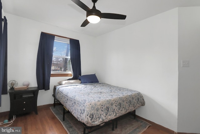 bedroom with a ceiling fan, baseboards, and wood finished floors