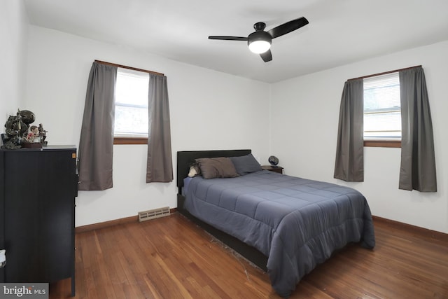 bedroom with visible vents, baseboards, dark wood-style floors, and a ceiling fan