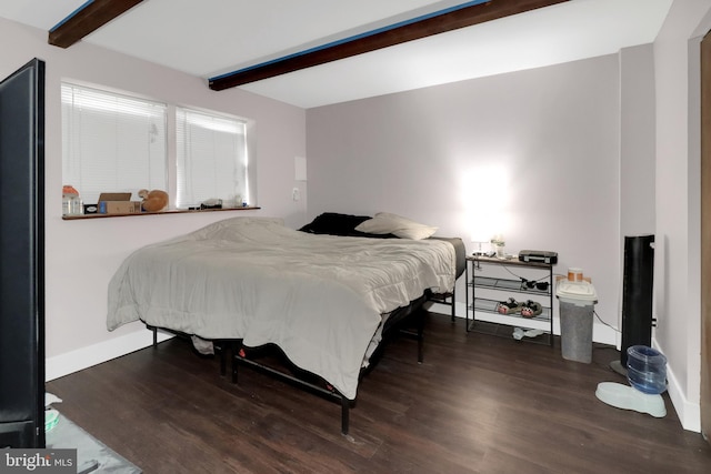 bedroom with beamed ceiling, wood finished floors, and baseboards