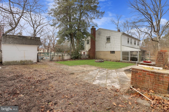 view of yard with an outbuilding, fence, a patio, and a sunroom